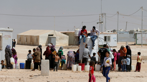 Refugiados sirios recogen agua en el campamento de Al-Zaatari en Mafraq, Jordania, cerca de la frontera con Siria. REUTERS / Muhammad Hamed