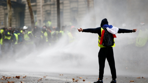 Un manifestante de los chalecos amarillos desafía a los antidisturbios durante las protestas en la Plaza de l'Etoile en París.- Stephane Mahe/REUTERS