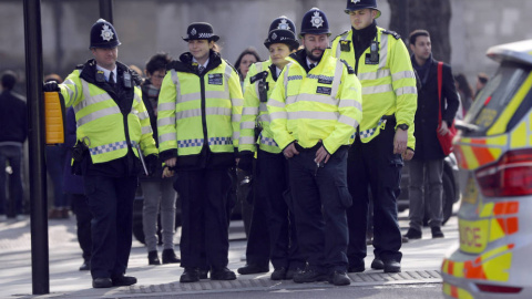 Agentes de policía se disponen a cruzar una calle ante el Parlamento británico. Reuters