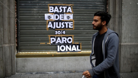 Un hombre para junto a un cartel que llama a la huelga, este martes en Buenos Aires. REUTERS/Agustín Marcarian