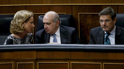 El ministro de Interior, Jorge Fernández (c), conversa con la diputada de Coalición Canaria, Ana Oramas (i), junto al ministro de Justicia, Rafael Catalá (d), hoy durante el pleno del Congreso de los Diputados. /EFE