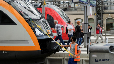 Un empleado del servicio limpia la ventana delantera de un tren en Alemania