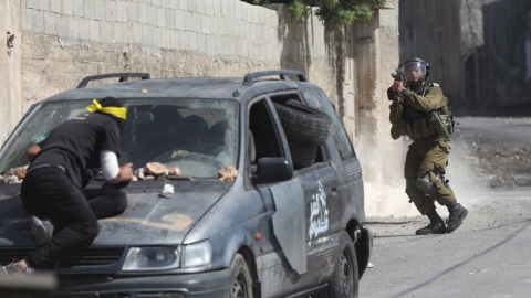 Un soldado israelí apunta su arma durante enfrentamientos con manifestantes palestinos.