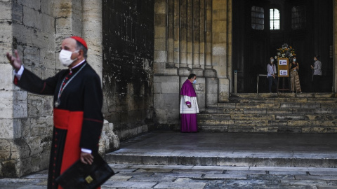 Imagen de archivo de un sacerdote con mascarilla espera al patriarca Manuel Clemente (izquierda) antes de celebrar la misa dominical en la catedral de Lisboa