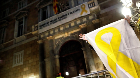 20/03/2019.- Una mujer muestra una pancarta con una lazo amarillo ante el Palau de la Generalitat. / EFE - ALEJANDRO GARCÍA