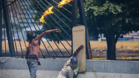 Opositores se enfrentan con la policía en una manifestación este miércoles en las calles de Caracas (Venezuela). /EFE