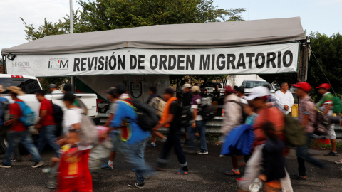 Migrantes de la caravana que viaja hacia EEUU pasan por un punto de revisión de orden migratorio. REUTERS/Carlos Garcia Rawlins