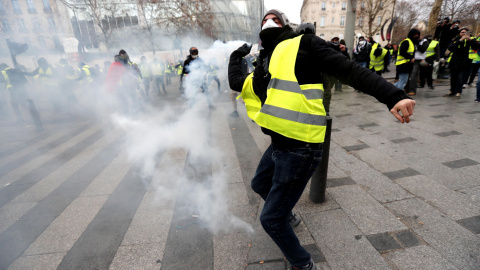 Un manifestante devuelve una granada de gas lacrimógeno a la Policía en París.- EFE/EPA/Ian Langsdon