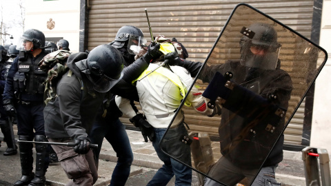 Los antidisturbios, protegidos con escudos, detienen a un manifestante de los chalecos amarillos en París. REUTERS/Christian Hartmann