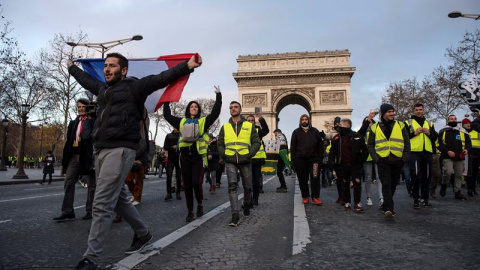 Manifestantes de los chalecos amarillos caminan por los Campos Elíseos de París./ EFE/EPA/Julien de Rosa