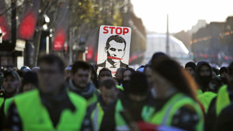 Los chalecos amarillos portan una pancarta contra Macron en la manifestación de este sábado en París..EFE/Ian Langsdon