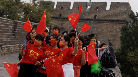 Varias personas en la Gran Muralla con banderas de China, el día de la Fiesta Nacional, el pasado 1 de octubre. REUTERS/Thomas Peter