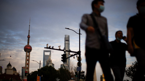 Varias personas caminando por la calle en Shanghái, con la Torre de la Perla Oriental al fondo. REUTERS/Aly Song