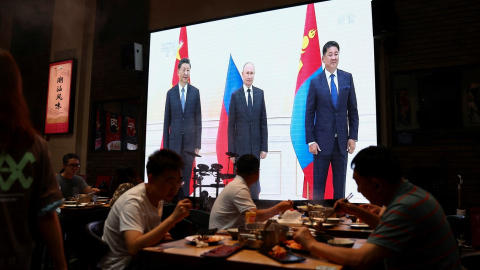 Una pantalla gigante en un restaurante de Pekín transmite imágenes del presidente chino Xi Jinping, con el presidente ruso Vladimir Putin y con el presidente mongol Ukhnaa Khurelsukh, durante la cumbre de la Organización de Cooperación de Shanghai (OC