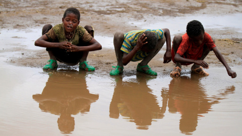 Varios niños se lavan en un charco en la ciudad de Kobo, Etiopía. - REUTERS