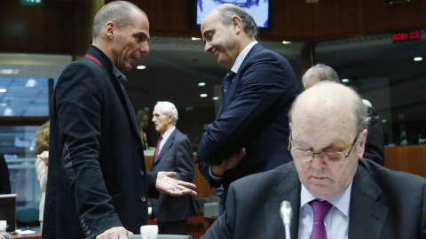 El ministro de Finanzas griego, Yanis Varoufakis, conversa con el mionistro español de Economía, Luis de Guindos, cerca de donde está sentado el ministro irlandés Michael Noonan, antes del comienzo de la reunión del Ecofin, en Bruselas. REUTERS/Franc