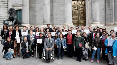 Varios diputados posan junto a miembros de diferentes colectivos a las puertas del Congreso de los Diputados, donde se ha debatido la reforma de la Ley Orgánica de Régimen Electoral General (Loreg) que otorgará el derecho de sufragio a todas las person