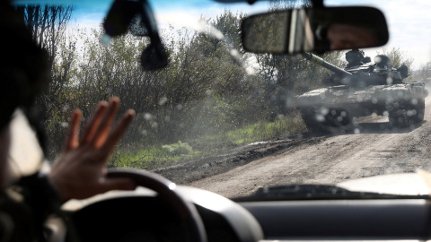 Un conductor pasa junto a un tanque ucraniano que circula por una carretera en la región de Donetsk.