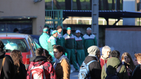 Al fondo, varios trabajadores del matadero de Getafe observan a un grupo de animalistas que se concentra a las puertas del centro para realizar una vigilia vegana./ Alejandro Tena