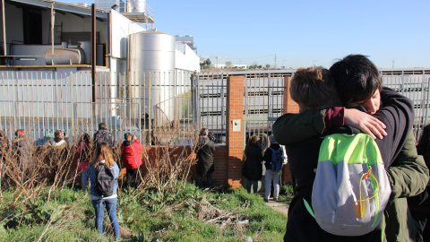 Dos de los asistentes a la vigilia se abrazan mientras presencian cómo se descarga un camión de cerdos./ Alejandro Tena