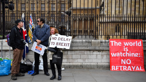 Un manifestante pro-brexit sostiene una pancarta a las puertas del Parlamento en Londres. | Reuters