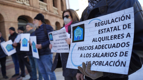 Un grupo de personas con pancartas de 'Regulación Estatal de alquileres a precios adecuados a los salarios de la población' durante una concentración de la Plataforma de Afectados por la Hipoteca (PAH) para exigir una ley de derecho a la vi