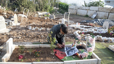 Un niño entierra a una persona cercana en Tulkram, Palestina.