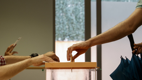 Foto de archivo de una persona introduciendo su voto en una urna