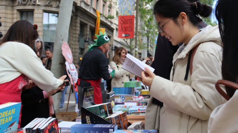 Una dona mira llibres en una parada de Les Rambles.