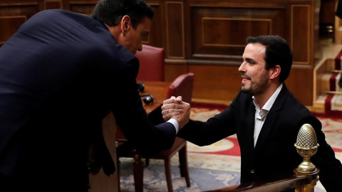 El coordinador de Izquierda Unida, Alberto Garzón (d), saluda al candidato a la Presidencia del Gobierno, Pedro Sánchez (i), tras su intervención ante el pleno del Congreso de los Diputados en la primera jornada de la sesión de investidura 