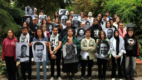 Fotografia de família d'alguns dels defensors dels drets humans reunits a la UB amb fotos d'altres activistes detinguts, morts o exiliats