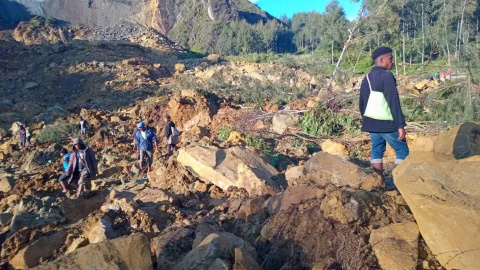 Personas sobre el deslizamiento de tierra originado en la aldea Kaokalam en la provincia de Enga, Papúa Nueva Guinea, a 24 de mayo de 2024.