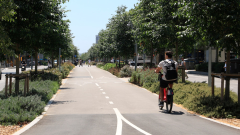 Un jove circula en bicicleta pel carril bici bidireccional al centre de l'avinguda Meridiana de Barcelona, a l'altura del carrer de Josep Estivill