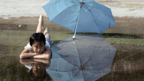 03/06/2024-Un niño mojado con un paraguas al lado, señal de que la Niña trae precipitaciones