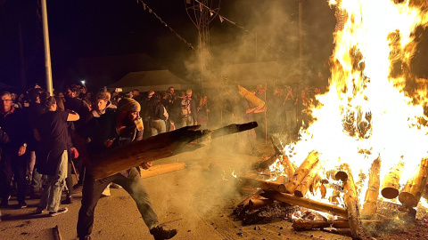 Un fallaire en el moment de tirar la falla a la foguera a Isil (Alt Àneu), en una imatge d'arxiu