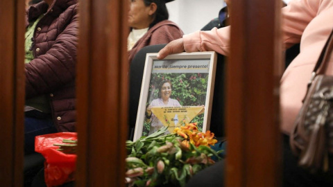 Una asistente al tribunal muestra una imagen en recuerdo de una de las campesinas víctimas de violación por parte de militares, en Lima, a 20 de junio de 2024.