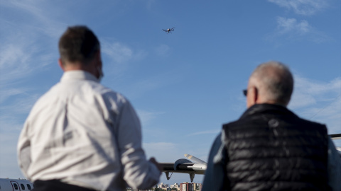 Varias personas observan un dron, durante la operación combinada entre drones y aviones, en el aeródromo de Cuatro Vientos, a 28 de octubre de 2021, en Madrid.