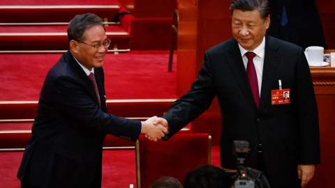 El presidente chino, Xi Jinping, le da la mano a Li Qiang (izquierda), nuevo primer ministro chino, durante la Tercera Sesión Plenaria de la Asamblea Popular Nacional (APN).