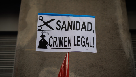 Una pancarta que reza 'Sanidad, Crimen Ilegal' durante una protesta de los trabajadores del servicio de atención telefónica de la centralita de atención de emergencias del Summa 112, que atiende el 061, frente a la Consejería de Sanidad, a 