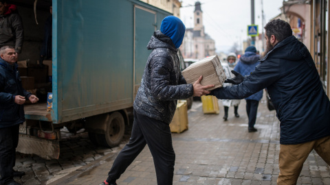 Varias personas descargan un camión con donaciones para un centro de refugiados ucranianos, a 4 de marzo de 2022, en el oeste de Ucrania.