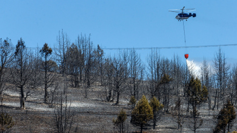 25/07/2022. Un helicóptero trabaja este lunes para extinguir el incendio que afecta desde ayer a la comarca del Arlanza en Burgos. Los tres grandes incendios que se han declarado este fin de semana en Castilla y León, aún activos, en Burgos