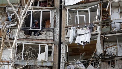 Un residente mira desde el frente destruido de una habitación en un edificio de varios pisos que resultó gravemente dañado como resultado de la explosión de un misil ruso después de que fue derribado sobre la ciudad por la defensa aérea ucr