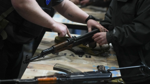 Instructores de armamento enseñan a manejar armas de guerra a civiles ucranianos, para la defensa de la ciudad ucraniana de Lviv (Oeste de Ucrania), este sábado en la Filmoteca de la ciudad.- EFE / Borja Sánchez Trillo