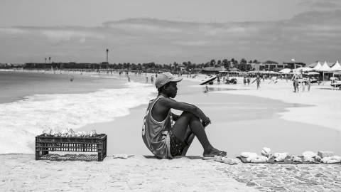 27/3/23 Un chico sentado en el paseo de piedra en la playa en Santa María | Alba Díaz.