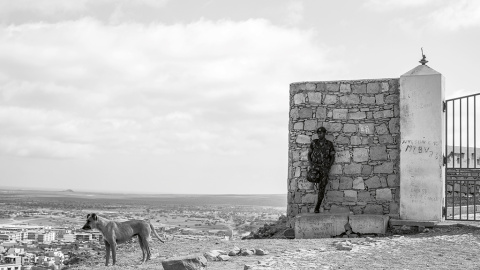 27/3/23 Un militar apoyado en la pared y un perro, en Espargos | Alba Díaz.