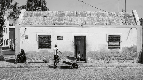 27/3/23 Un niño camina con una carretilla delante de una vivienda en Palmeira | Alba Díaz.