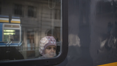 Un niño mira desde la ventana de un tren al llegar desde Przemysl, Polonia.