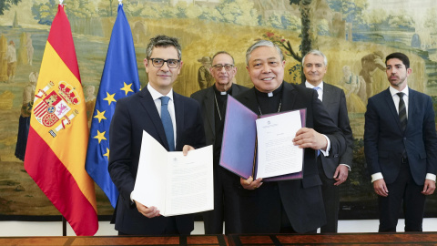 El ministro de la Presidencia, Félix Bolaños (i), intercambia documentos con el Nuncio en España, el arzobispo Bernardito Auza (d), durante un encuentro celebrado este miércoles en Madrid