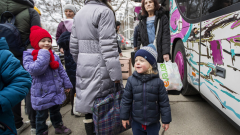 Mujeres y niños que huyen de Ucrania se preparan para tomar un autobús a Alemania, cerca de un centro de clasificación de refugiados en un estadio deportivo en Chisinau, Moldavia.