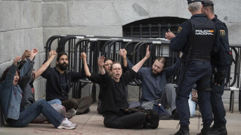 Efectivos de la Policía Nacional detienen a los activistas de Rebelión Científica que han lanzado pintura roja en la Puerta de Los Leones del Congreso a 30 de marzo de 2023